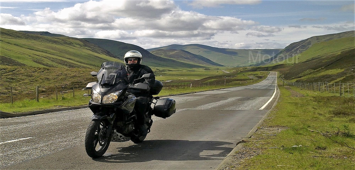 Motorrijder onderweg in the highlands, Glen Shee Schotland