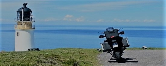 Motorfiets geparkeerd bij een vuurtoren tijdens motorreis naar Cornwall