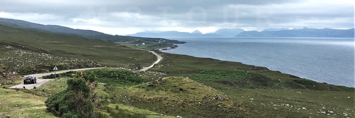 auto op smalle weg langs de kust Ierland